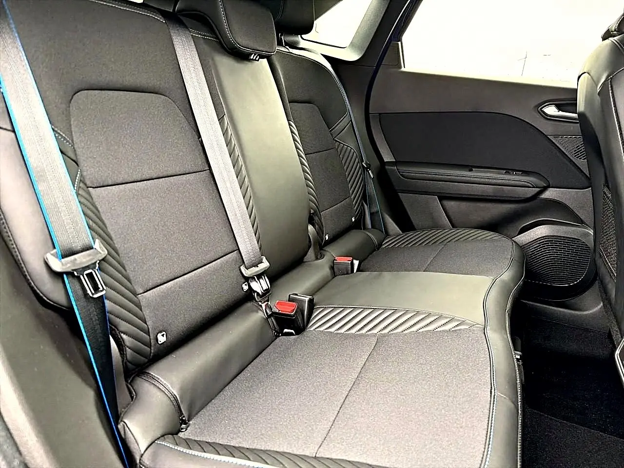 Vue intérieure sur la banquette arrière noire avec surpiqûres bleues du Renault Symbioz 2026.