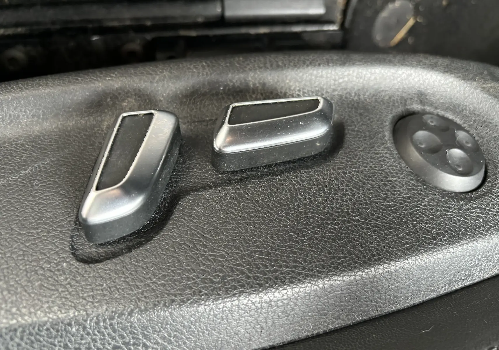 Détail des commandes de réglage électrique du siège en cuir noir d'une Audi A5 Sportback 2013.