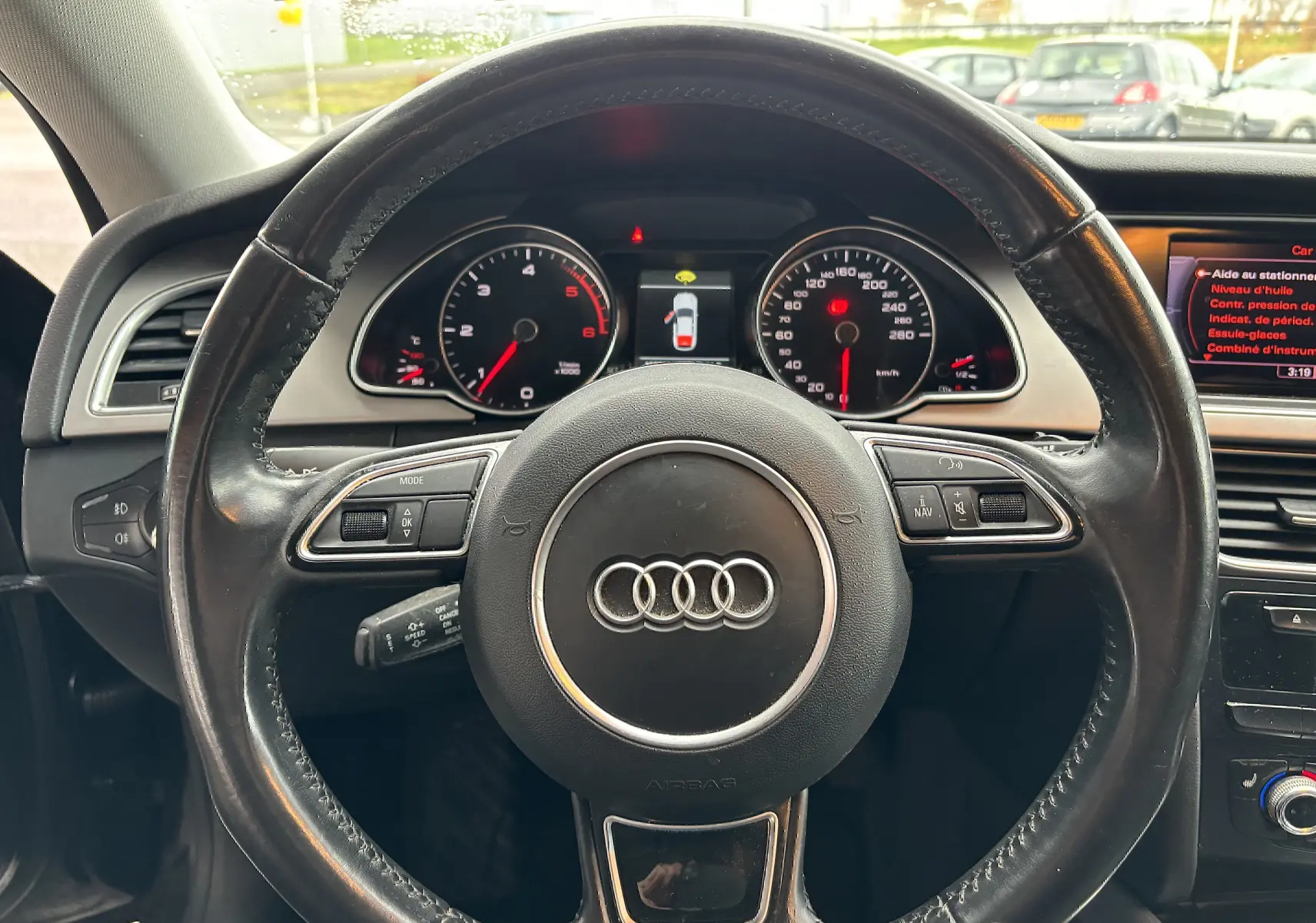 Vue intérieure centrée sur le volant en cuir noir d'une Audi A5 Sportback 2013 avec tableau de bord et affichage numérique.