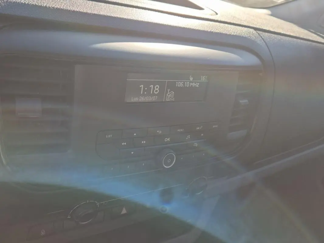 Tableau de bord intérieur du Citroën Jumpy blanc 2019, avec écran radio affichant la fréquence FM et commandes centrales.