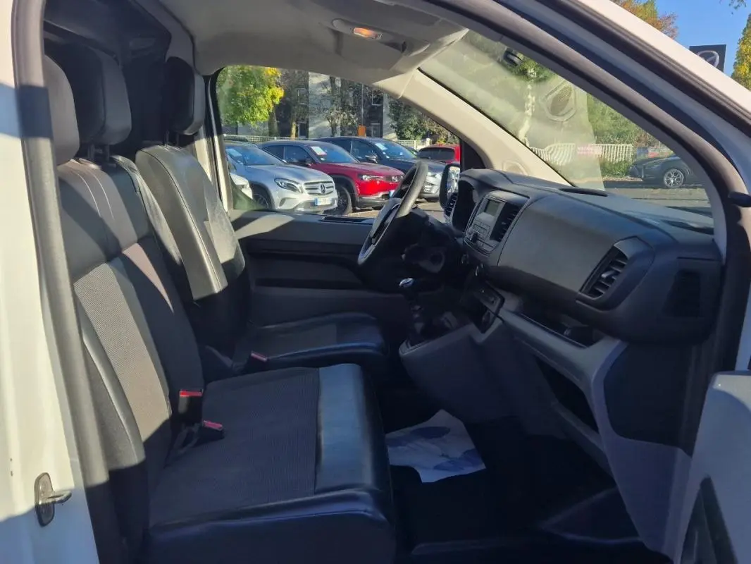 Vue intérieure côté conducteur du Citroën Jumpy blanc 2019, montrant les sièges avant et le tableau de bord.