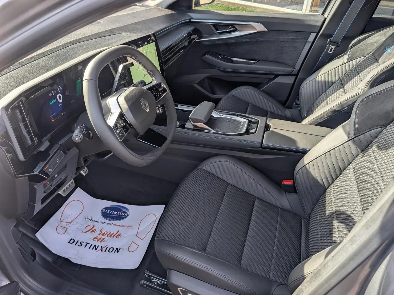 Vue intérieure côté conducteur du Renault Austral 2025 avec sellerie mixte tissu Alcantara et volant spécifique en textile noir.