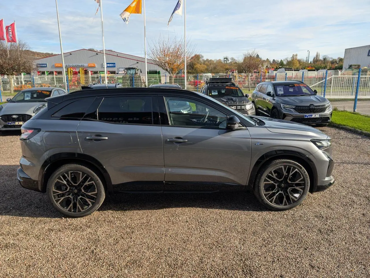 Renault Austral gris métallisé en profil droit, toit noir étoilé et jantes alliage 20 pouces diamantées.