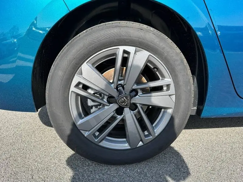 Gros plan sur la jante alu grise et le pneu du côté arrière droit d'une Peugeot 308 bleu Obsession.