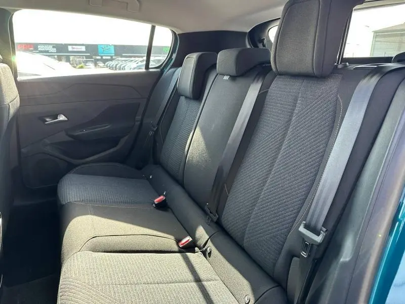 Vue latérale droite de la banquette arrière tissu gris foncé de la Peugeot 308 bleu 2025, avec ceintures de sécurité visibles.
