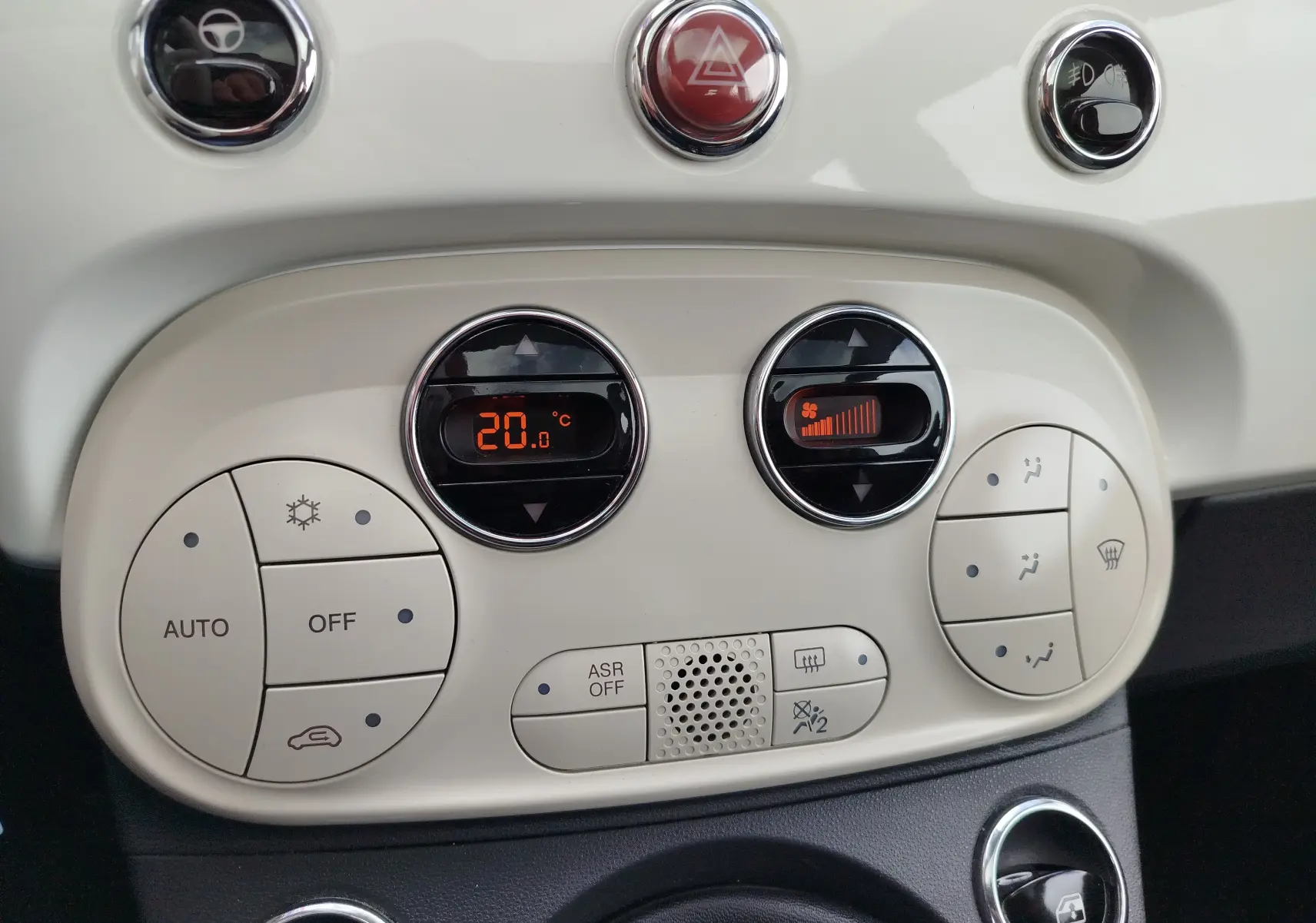 Vue rapprochée du tableau de bord blanc Bossa Nova avec commandes de climatisation digitale et boutons ronds sur Fiat 500 Lounge 2017.