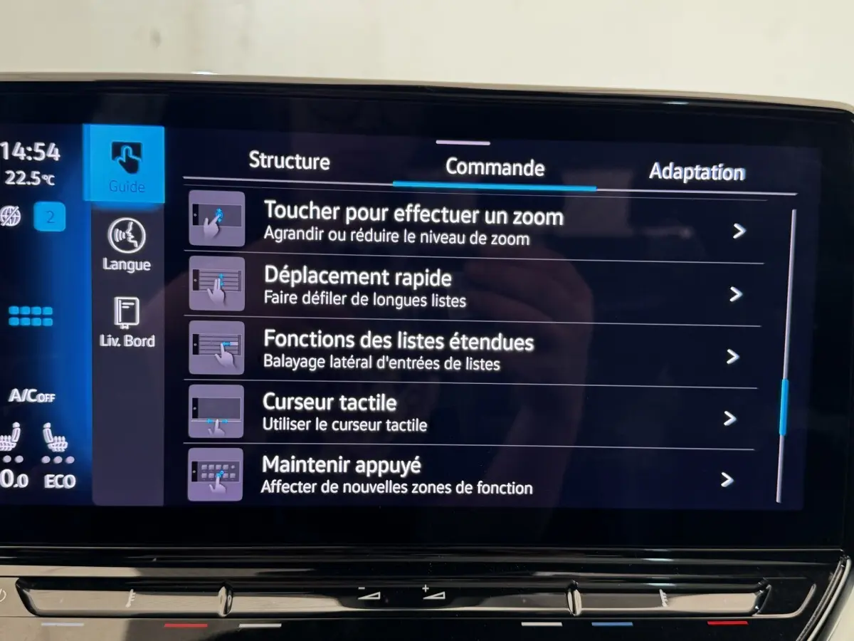 Écran tactile intérieur du Volkswagen ID.4 blanc, affichant les commandes de zoom et navigation du système multimédia.
