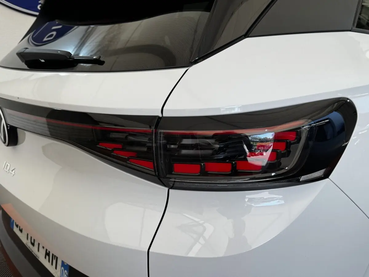 Gros plan sur le feu arrière droit noir et rouge du Volkswagen ID.4 blanc, vue arrière côté droit.