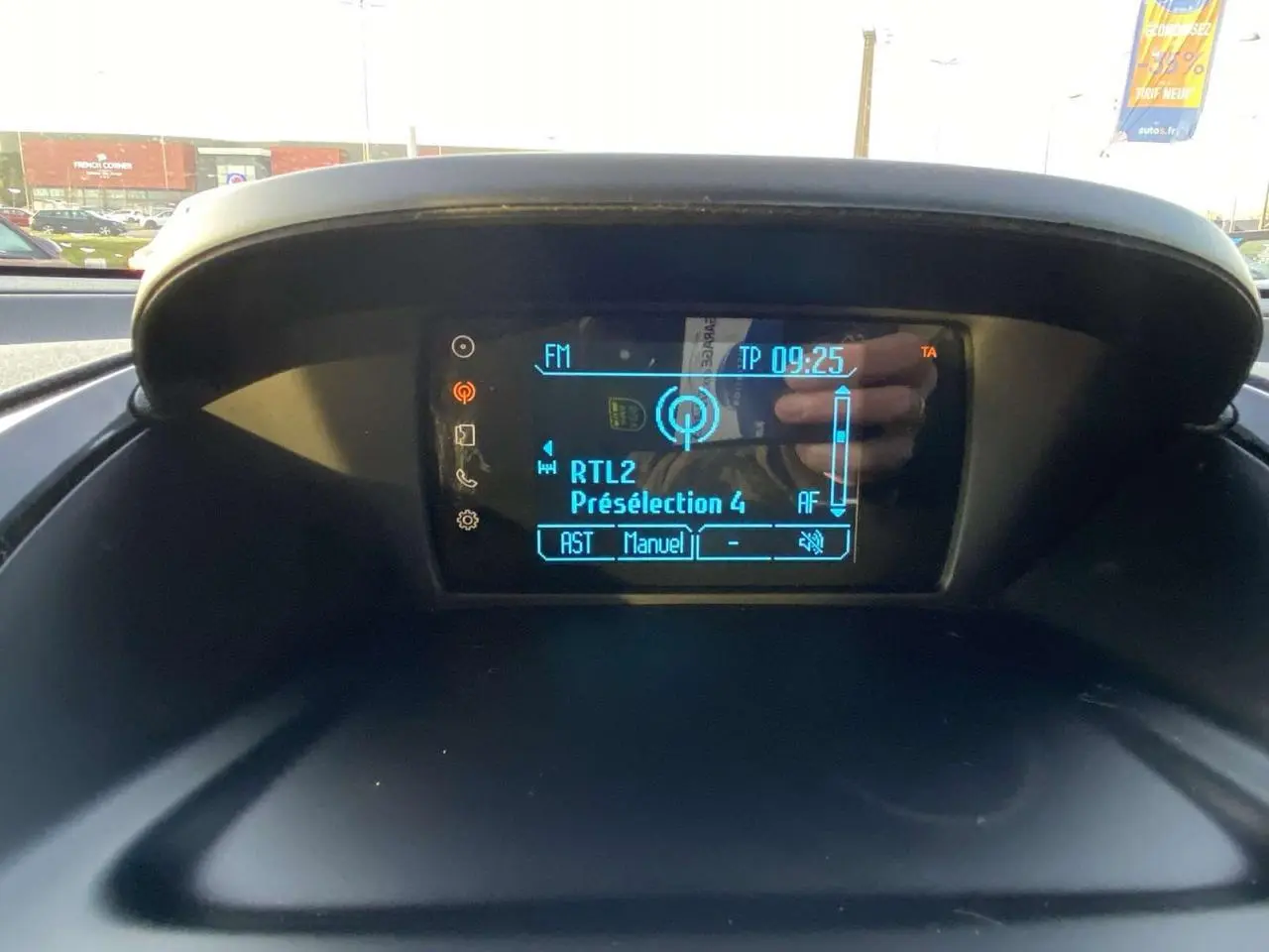 Écran central du tableau de bord de la Ford B-MAX 2014 affichant la radio FM RTL2 en extérieur lumineux.