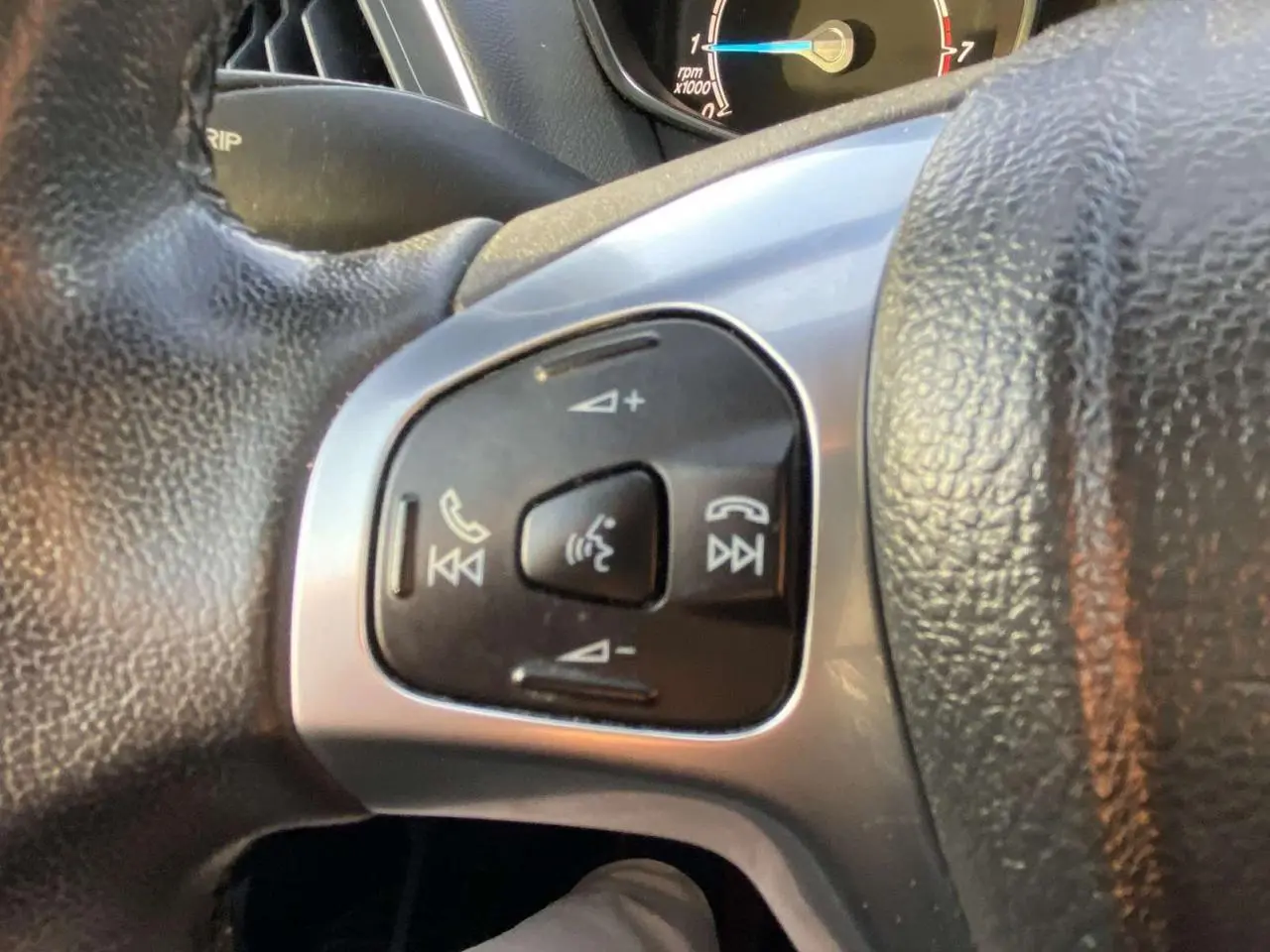 Gros plan sur les commandes vocales et téléphoniques au volant d’une Ford B-MAX blanche de 2014.
