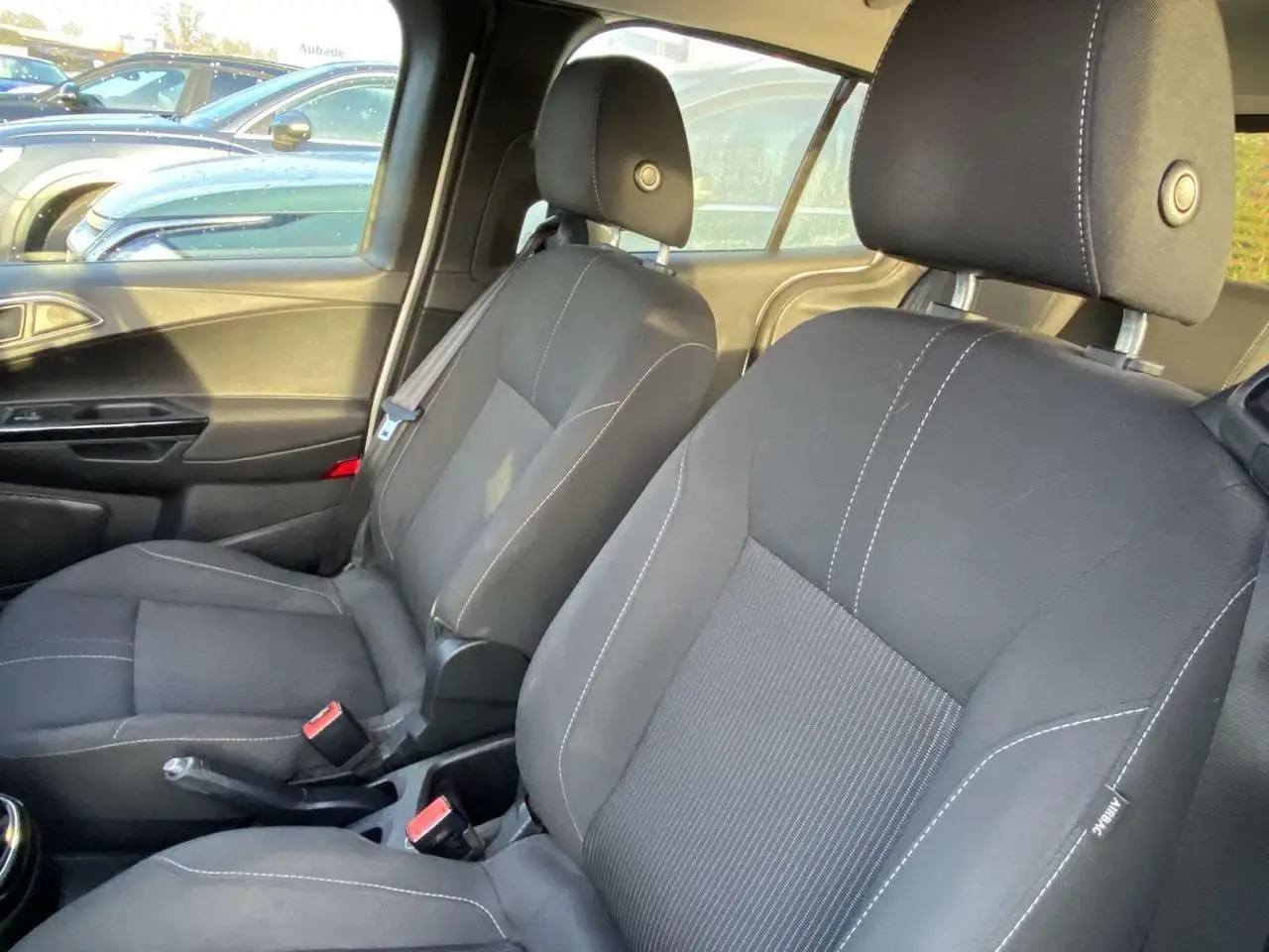 Vue intérieure sur les sièges avant noirs avec surpiqûres blanches d'une Ford B-MAX 2014, côté conducteur et passager.
