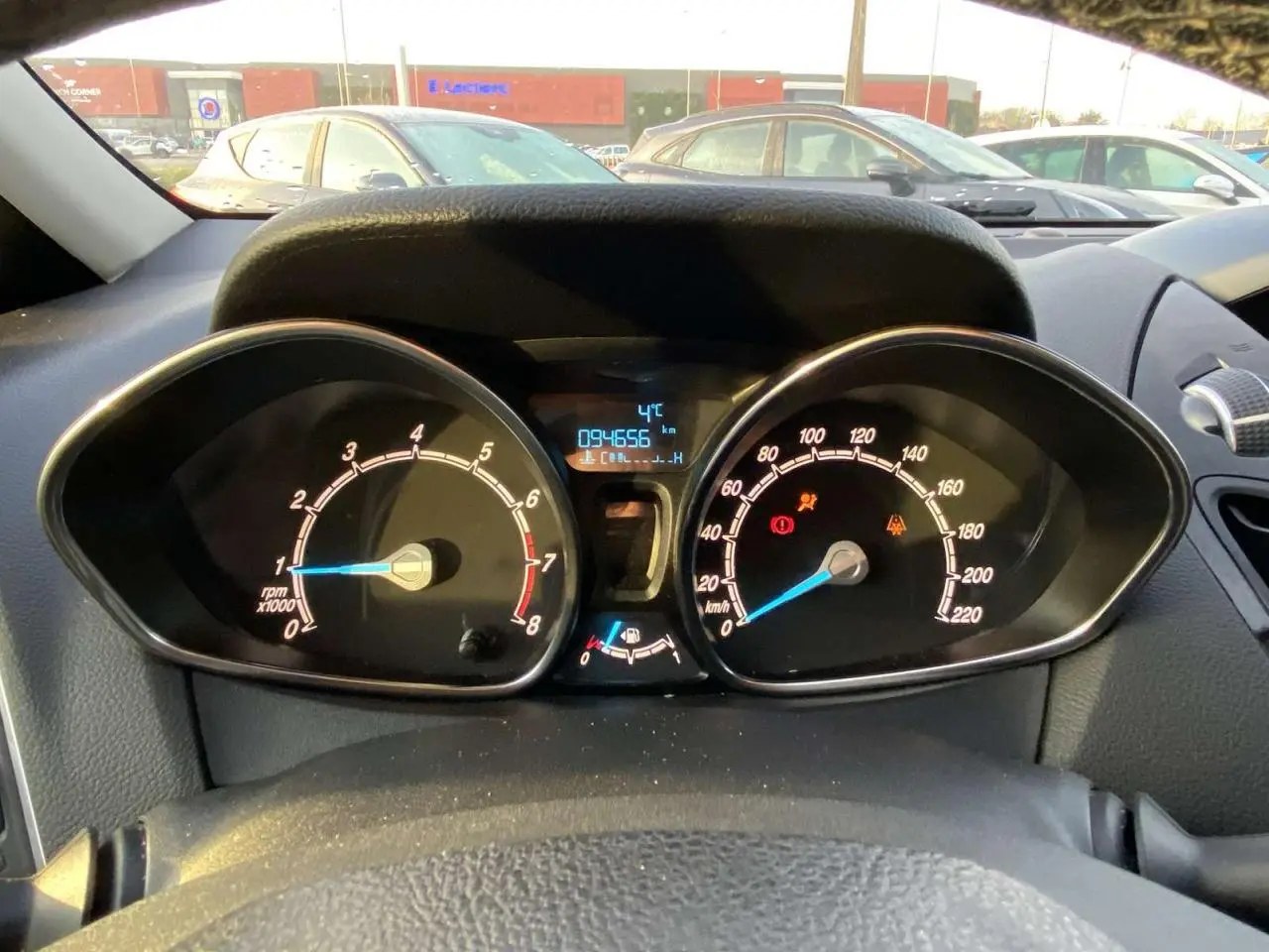 Vue intérieure du tableau de bord du Ford B-MAX blanc 2014, affichant compte-tours, compteur de vitesse et écran digital.