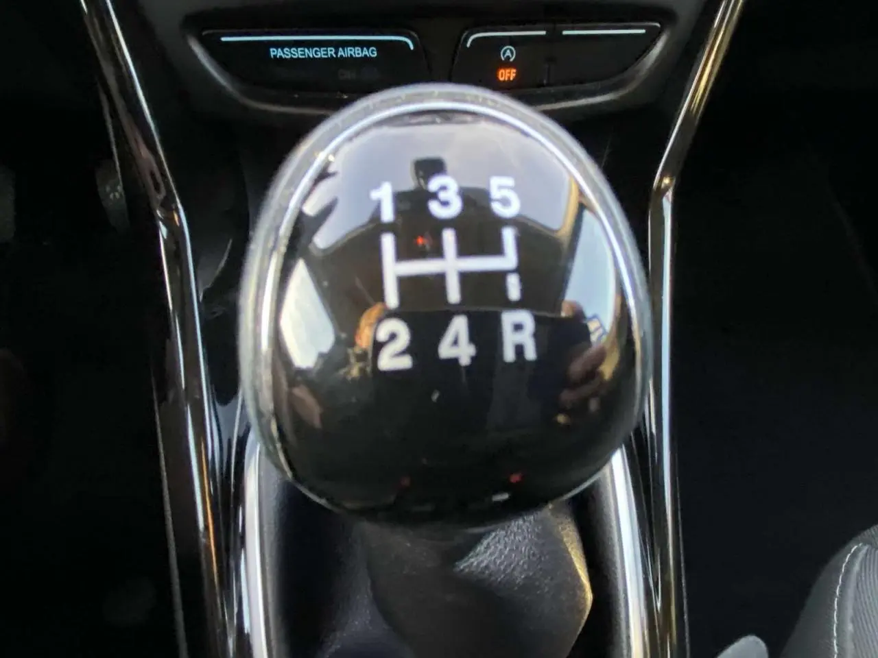 Le levier de vitesse manuel noir de la Ford B-MAX 2014, avec indication des rapports en blanc, vu en gros plan.