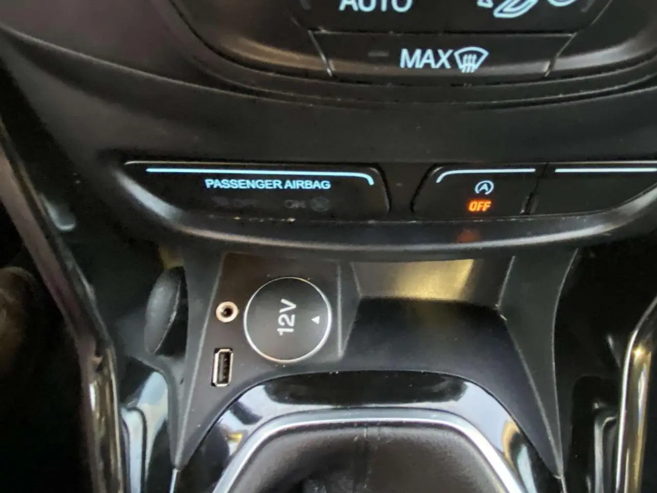 Vue rapprochée de la console centrale du Ford B-MAX blanc 2014, avec prise 12V et port USB visibles.
