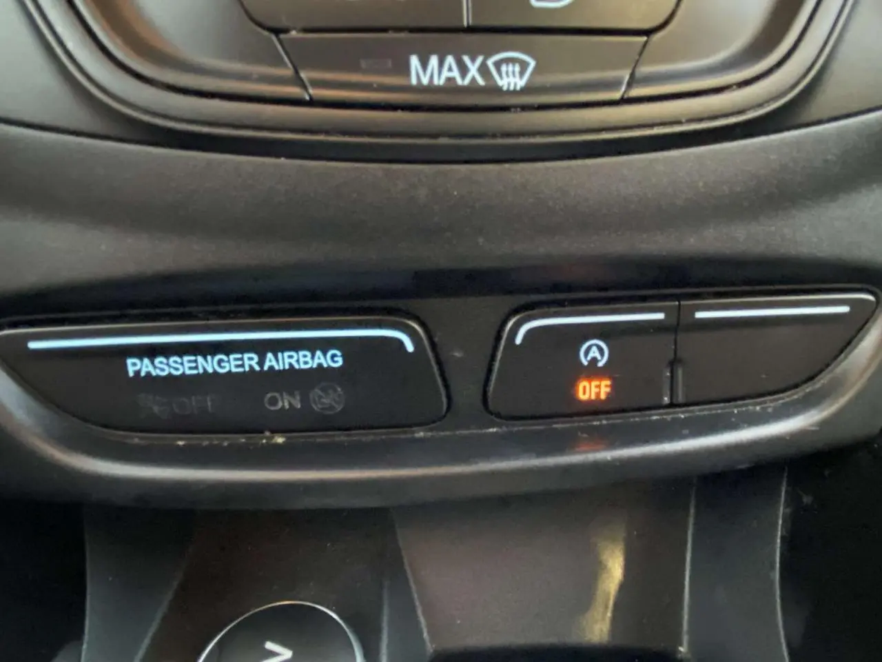 Gros plan sur les boutons de commande du système Stop & Start et de l'airbag passager dans un Ford B-MAX blanc de 2014.