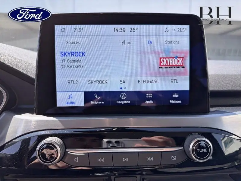 Écran tactile central du Ford Kuga 2023 affichant la radio Skyrock, avec commandes audio et navigation visibles.