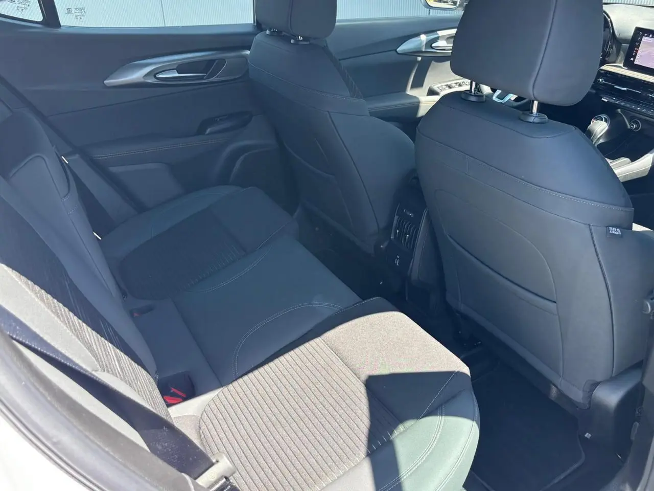 Vue intérieure arrière droite de l'Alfa Romeo Tonale blanc, sièges en cuir noir avec surpiqûres contrastées.