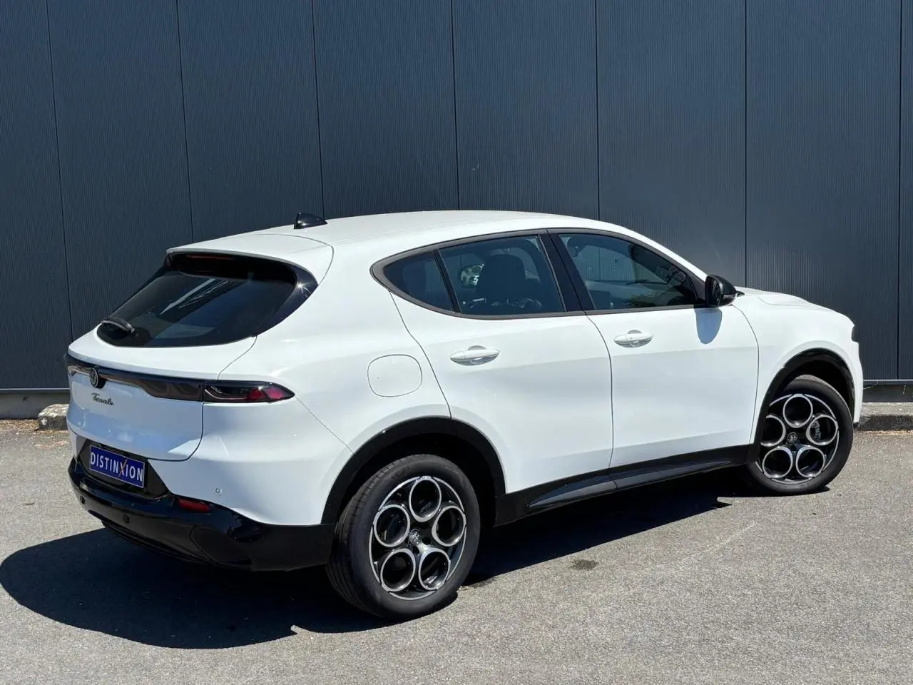 Vue 3/4 arrière droite de l'Alfa Romeo Tonale blanc métallisé avec jantes alliage 18 pouces et vitres teintées.