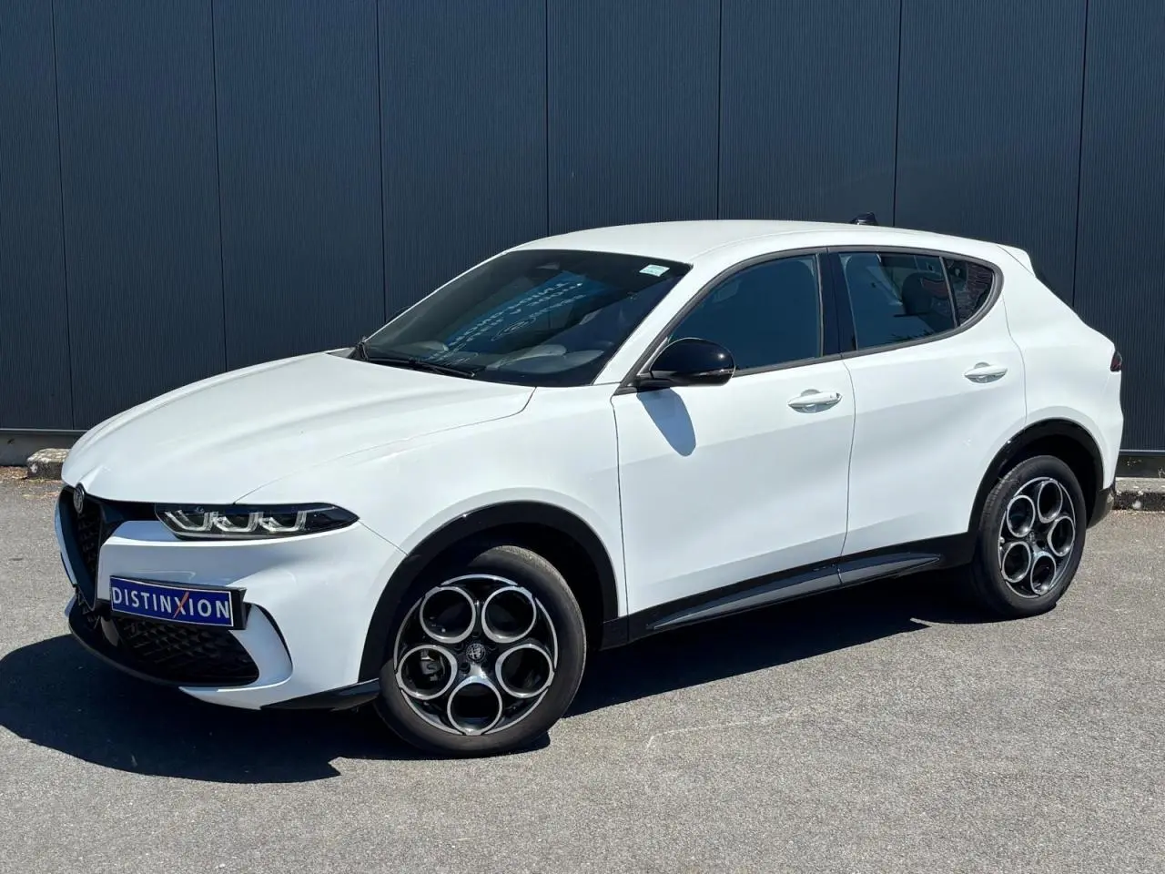 Alfa Romeo Tonale blanc en 3/4 avant droit, jantes alliage 18 pouces et rétroviseurs noirs contrastés.