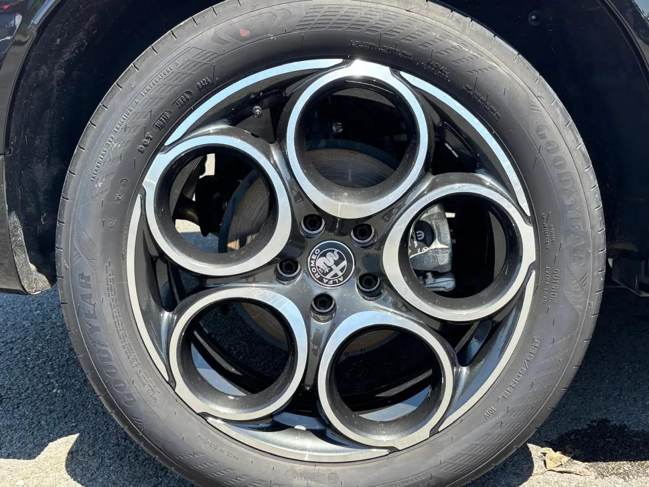 Gros plan sur la roue avant droite d’un véhicule blanc, mettant en valeur le pneu Goodyear et la jante en alliage.