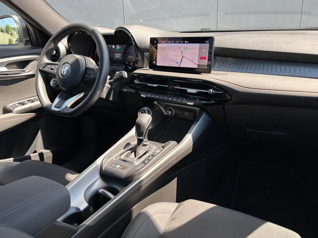 Intérieur de l'Alfa Romeo Tonale 1.5 Hybrid 130 Sprint vu côté conducteur, avec tableau de bord digital et écran tactile.