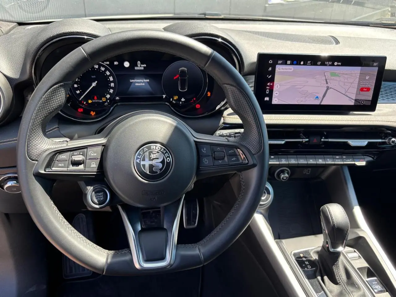 Vue intérieure centrée sur le volant cuir noir et le tableau de bord digital de l'Alfa Romeo Tonale 2025.