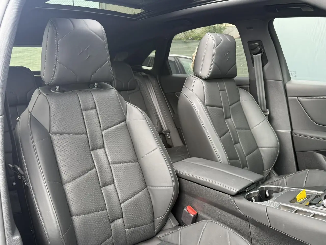 Intérieur DS7 2025 en cuir noir Basalte, vue rapprochée des sièges avant avec toit ouvrant panoramique visible.