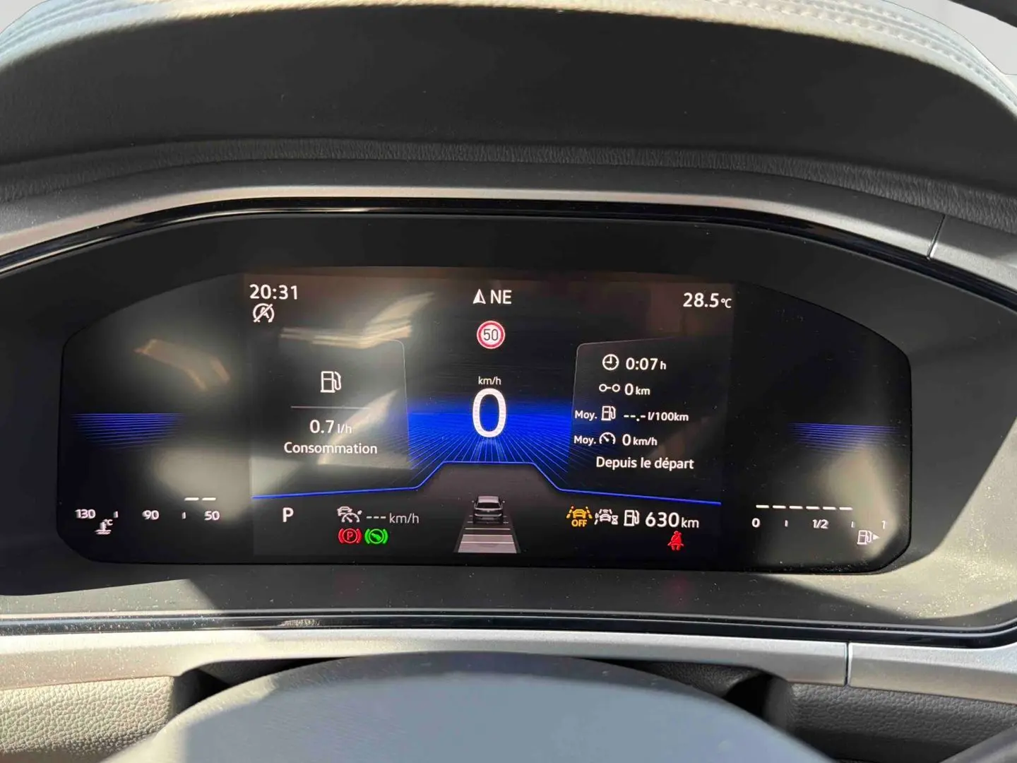Vue rapprochée du combiné d'instruments digital du Volkswagen T-Roc 2.0 TDI noir, affichant la vitesse et la consommation.