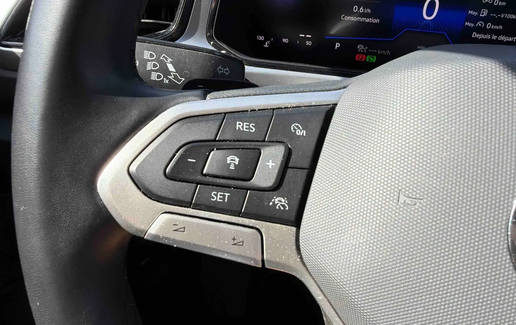 Gros plan sur le volant cuir multifonctions noir du Volkswagen T-Roc 2.0 TDI 150 DSG7 avec commandes de régulateur adaptatif.