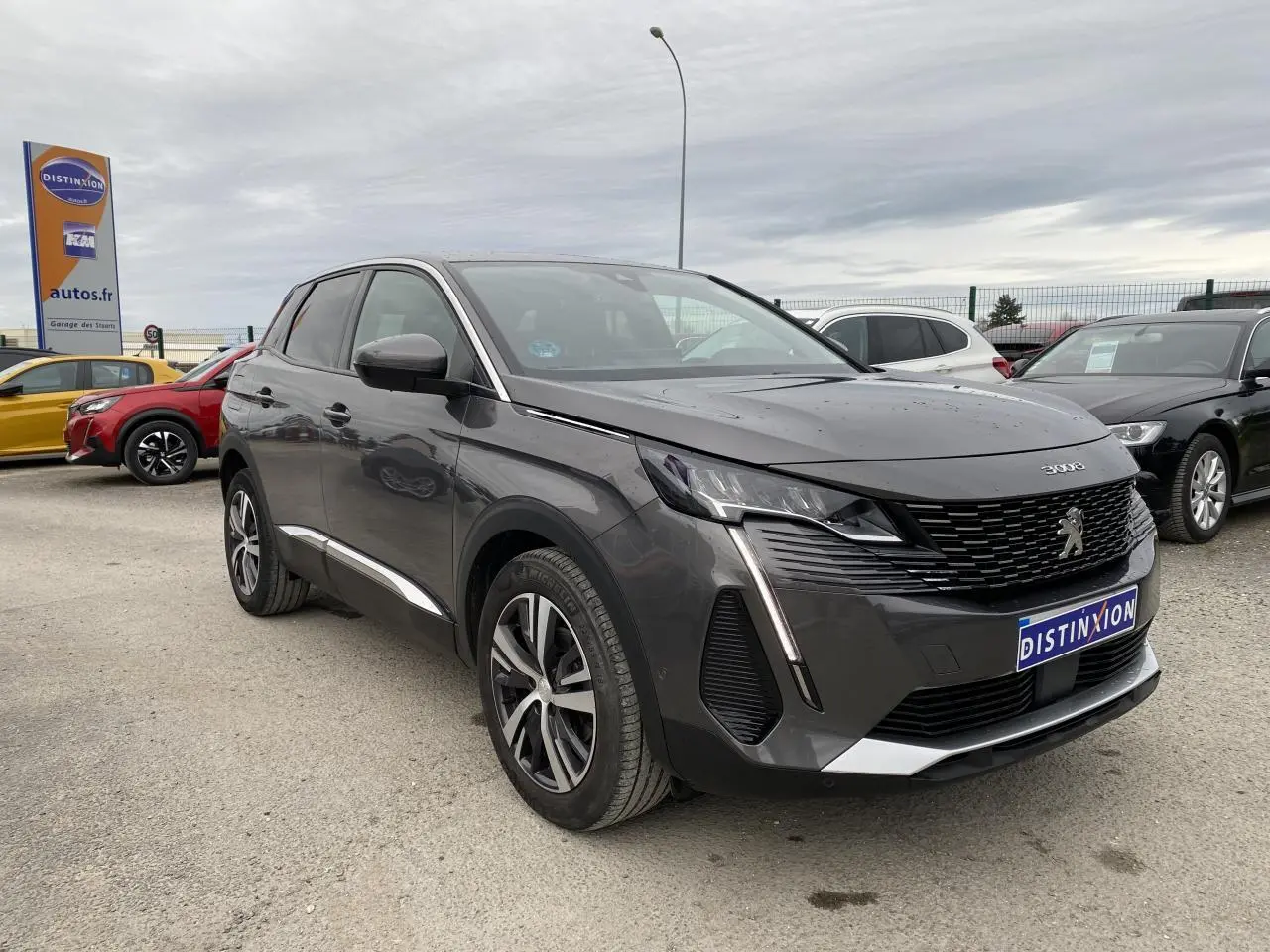Peugeot 3008 gris platinium vue 3/4 avant droit, avec calandre noire et feux LED verticaux distinctifs.