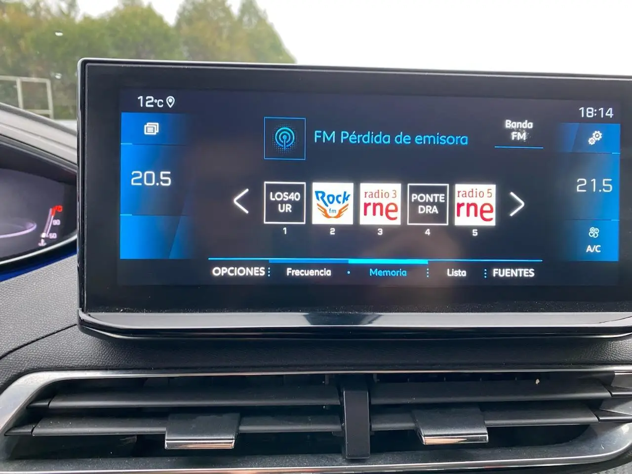 Écran tactile central du Peugeot 3008 gris platinium 2021 affichant les stations radio FM et la température intérieure.