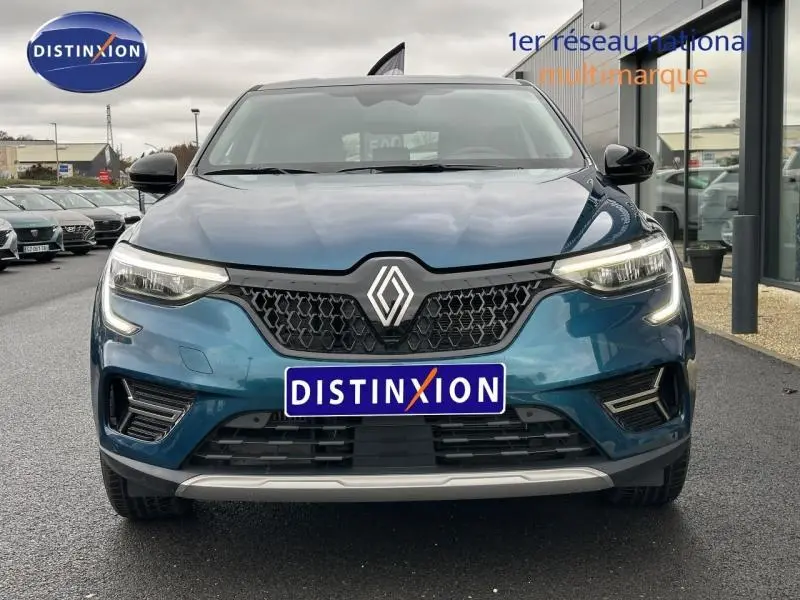 Vue frontale du Renault Arkana bleu Zanzibar 2025 avec calandre noire et éclairage LED allumé.