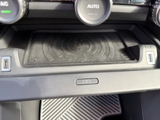 Détail du compartiment de chargement sans fil noir avec prises USB dans la console centrale d'une Citroën C4 gris Mercury.