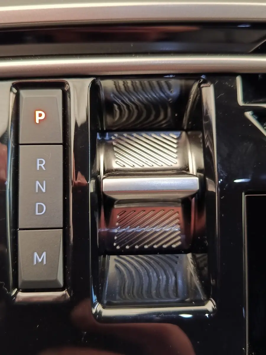 Gros plan sur la commande de boîte automatique noire du Peugeot 3008 1.2 Hybrid 136 GT, avec boutons P, R, N, D, M.