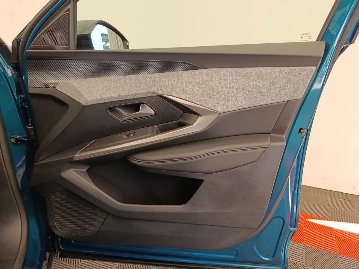 Vue rapprochée de la porte avant gauche bleu métallisé du Peugeot 3008 avec habillage tissu gris et cuir noir.