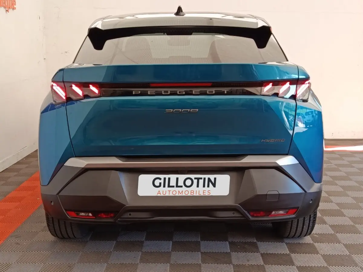 Vue arrière du Peugeot 3008 hybride bleu 2025 avec feux LED distinctifs et logo centré sur le hayon.
