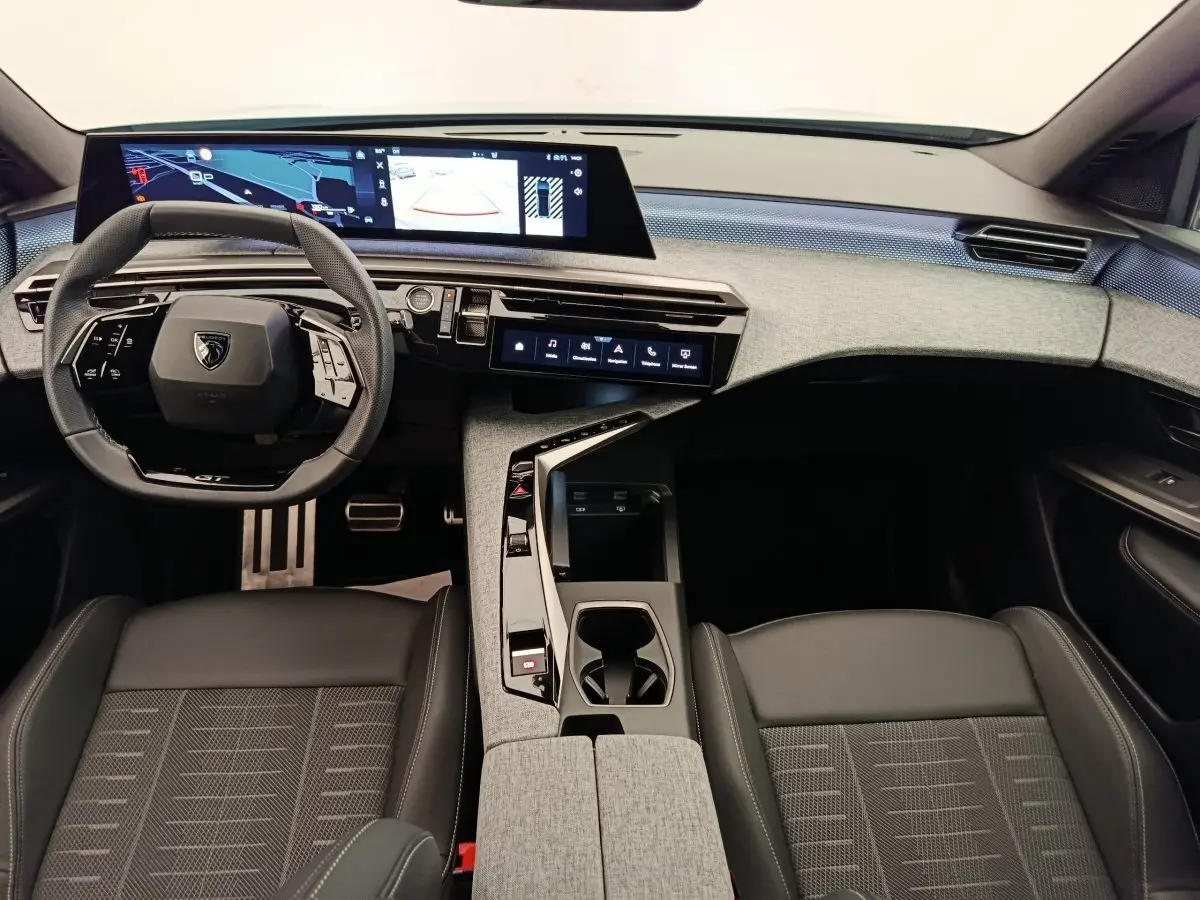 Vue intérieure avant du Peugeot 3008 1.2 Hybrid 136 GT avec tableau de bord moderne et volant cuir multifonctions.