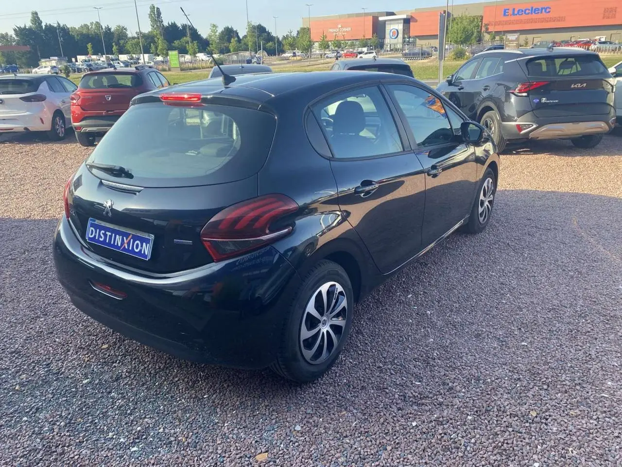 Vue 3/4 arrière droite d'une Peugeot 208 noire 2016 avec jantes acier et feux arrière distinctifs.