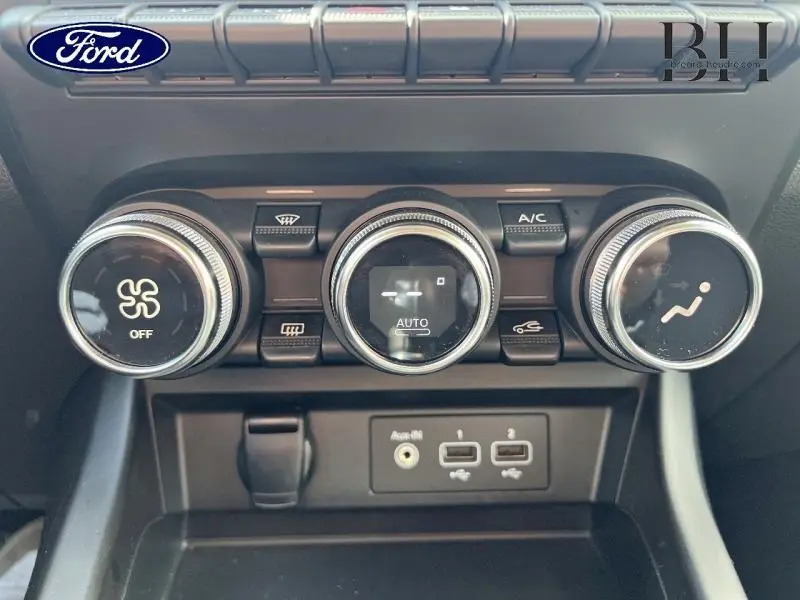 Vue rapprochée des commandes de climatisation et des ports USB d’un Renault Arkana blanc perle 2022.