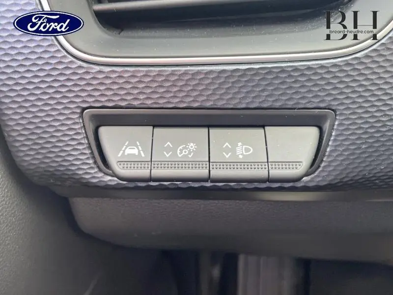 Panneau de commandes gris avec boutons de réglage d'assistance à la conduite et éclairage, intérieur de véhicule.