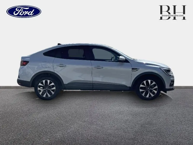 Profil droit d'un Renault Arkana blanc perle 2022 avec jantes alliage et vitres teintées sur fond neutre.