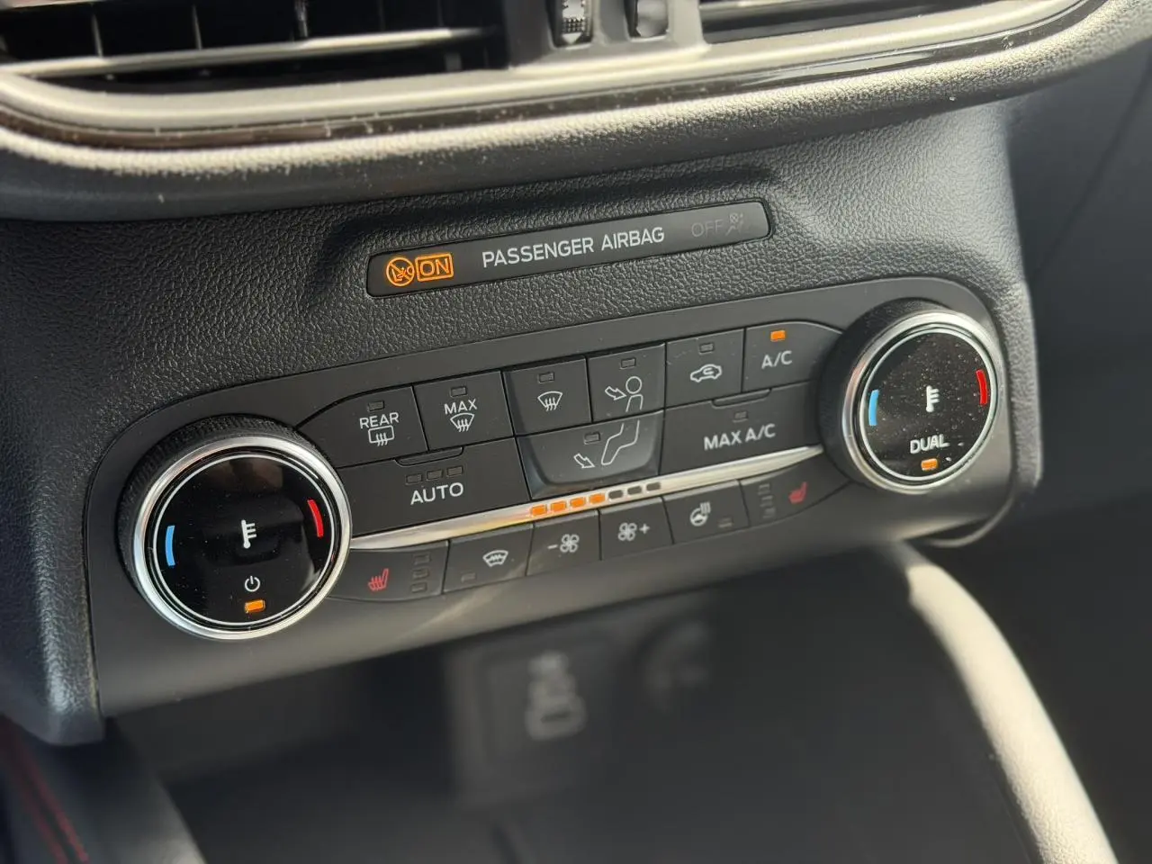 Gros plan sur la console de climatisation automatique du Ford Kuga gris Solar, avec commandes chauffantes et affichage digital.