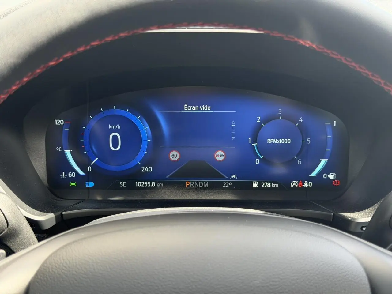 Vue rapprochée du combiné d'instrumentation numérique bleu du Ford Kuga 2023, affichant vitesse et compte-tours.