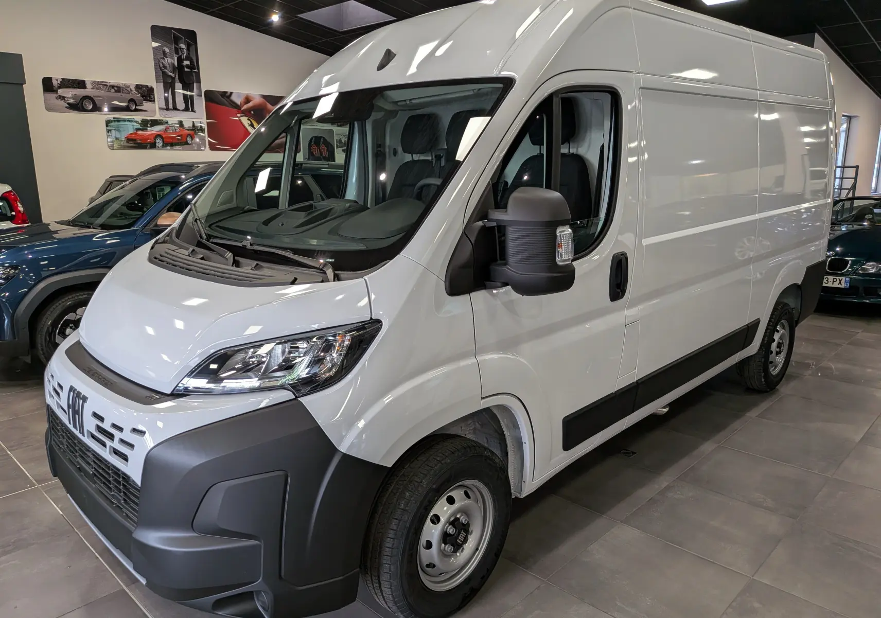 Vue 3/4 avant droite d’un fourgon blanc Fiat Ducato M H2 3.3T avec pare-chocs noir et rétroviseur élargi.