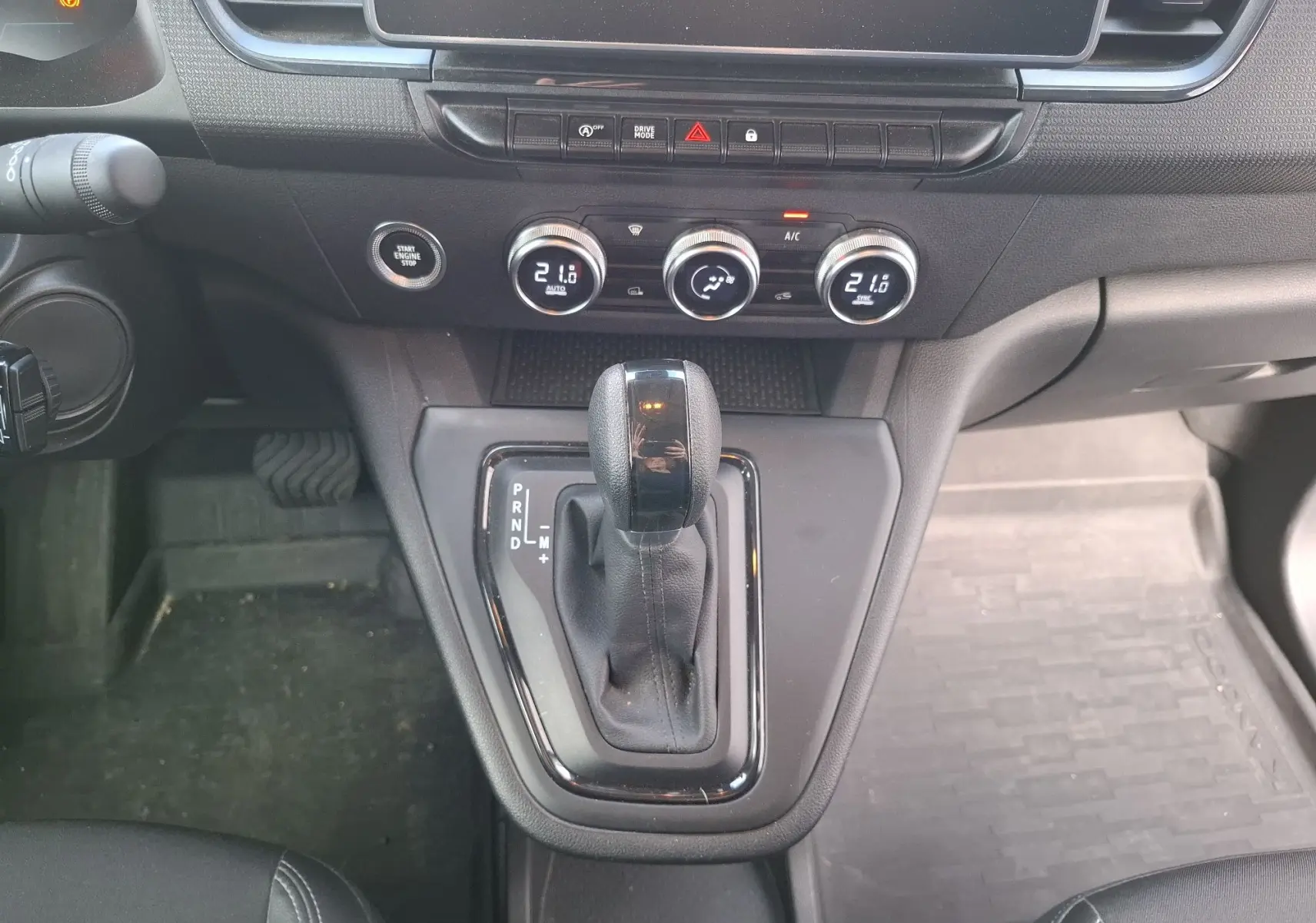 Gros plan sur la console centrale du Renault Kangoo Pro 2025 avec levier de boîte auto et commandes climatisation.