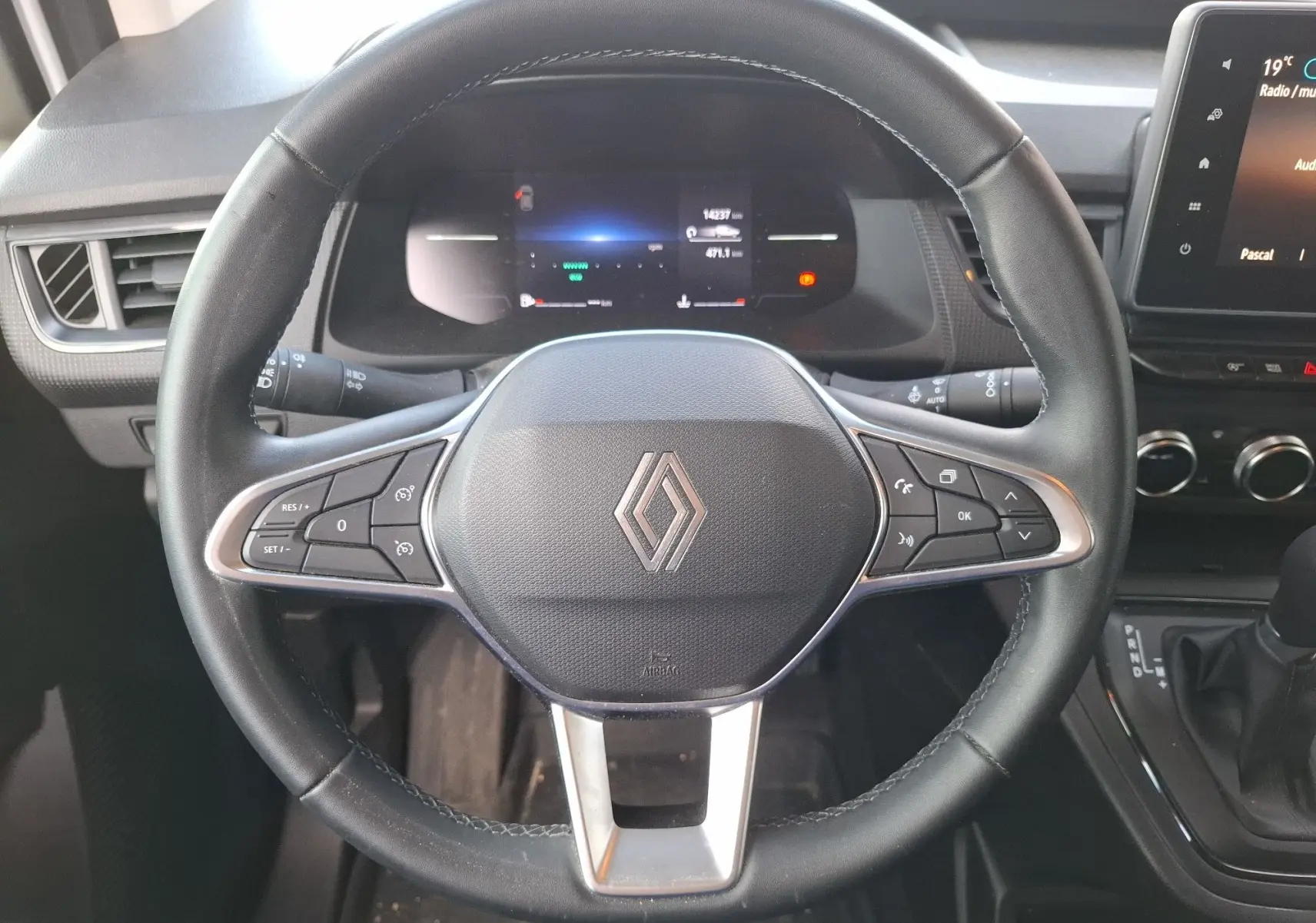 Vue rapprochée du volant noir du Renault Kangoo Pro 2025 avec commandes intégrées et tableau de bord digital.