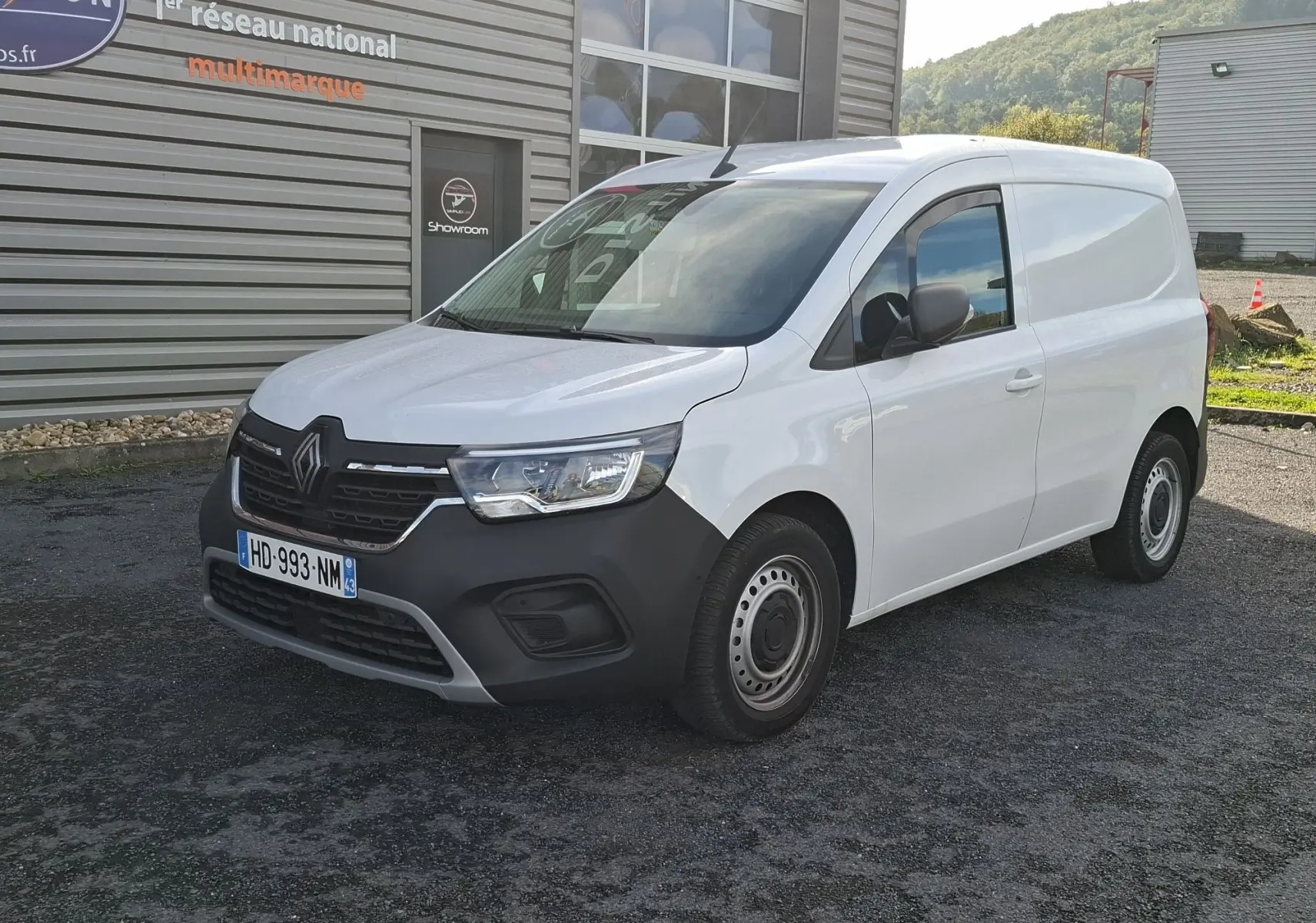 Renault Kangoo Pro blanc en 3/4 avant droit, fourgon utilitaire avec pare-chocs noir et jantes acier.
