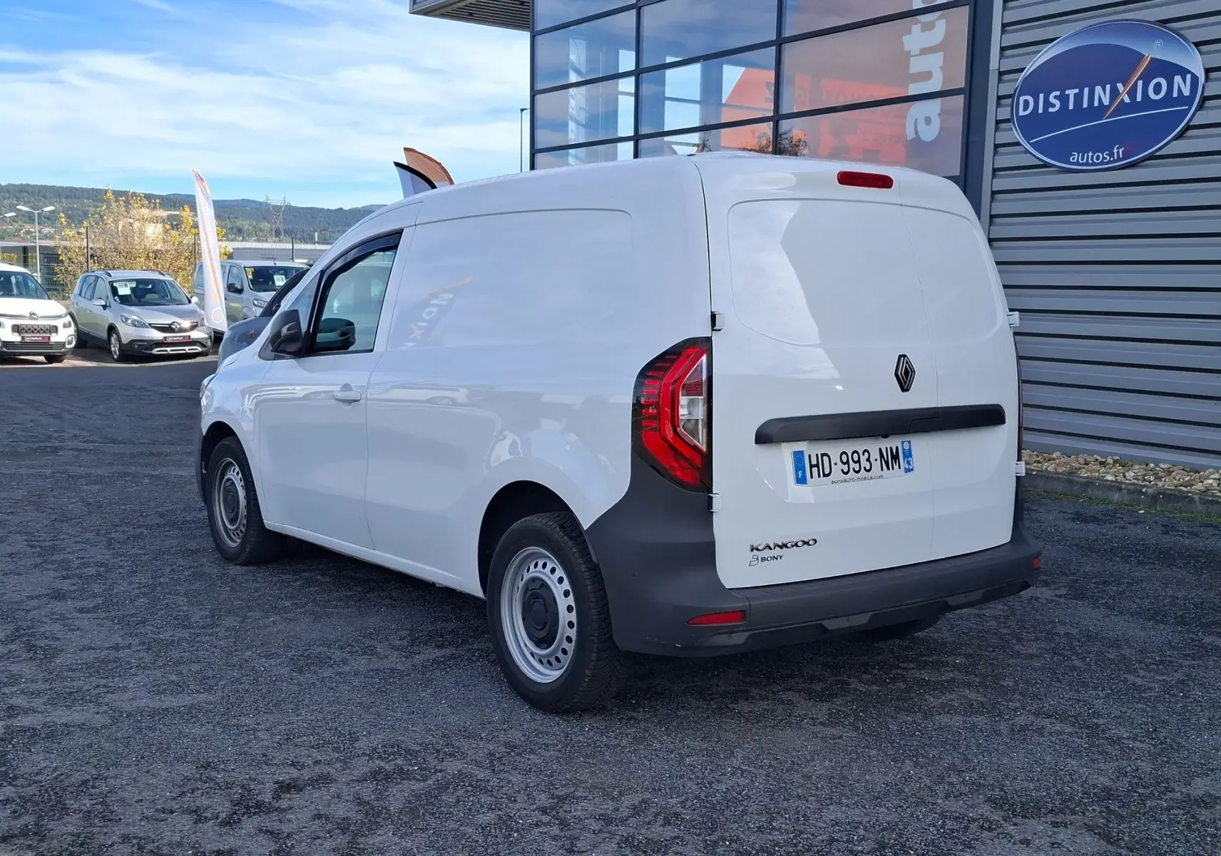 Vue 3/4 arrière droite d’un Renault Kangoo Pro blanc, fourgon utilitaire avec feux arrière distinctifs et plaque d’immatriculation visible.