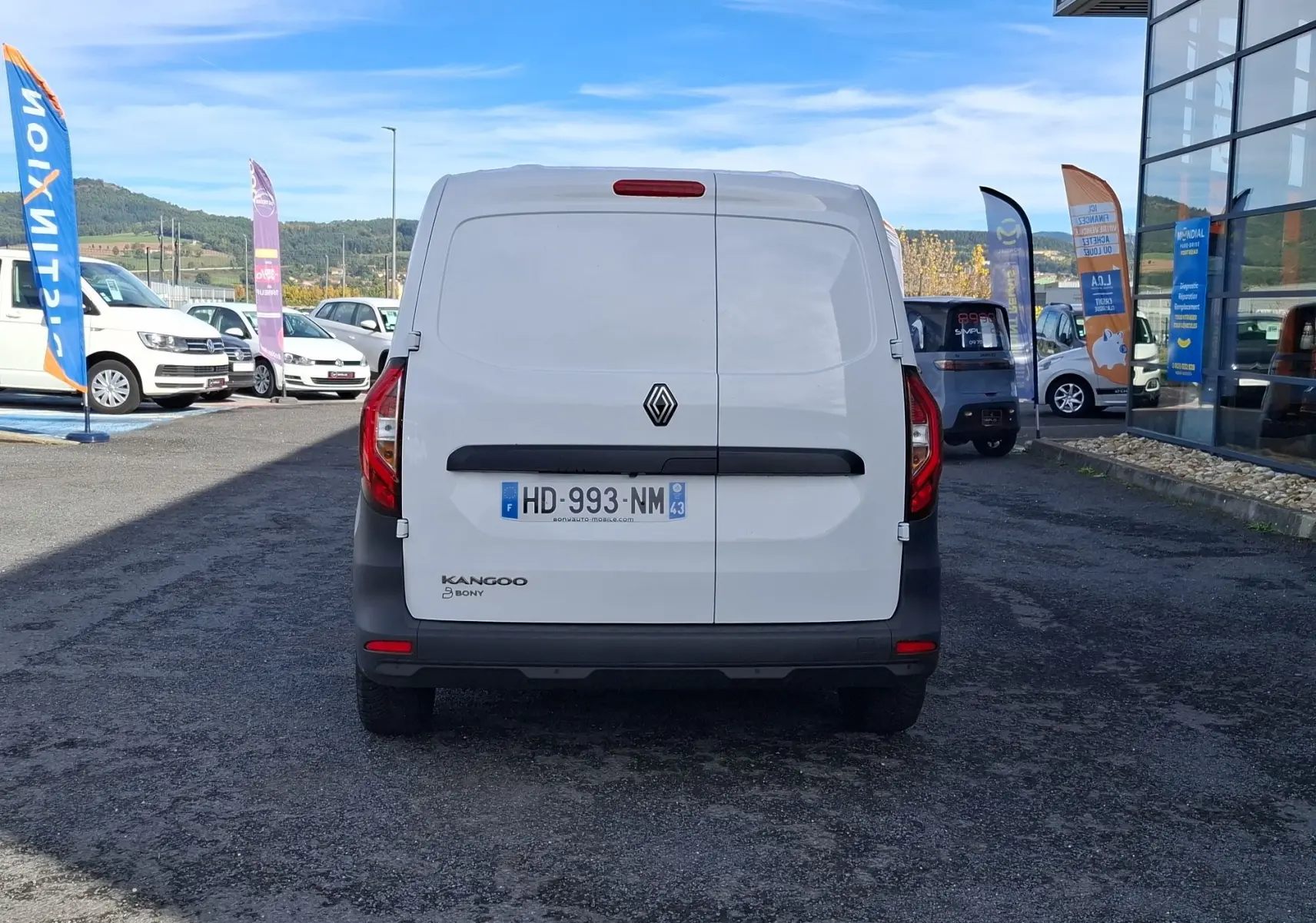 Vue arrière d’un Renault Kangoo Pro blanc, fourgon utilitaire avec logo et plaques visibles, stationné en extérieur.