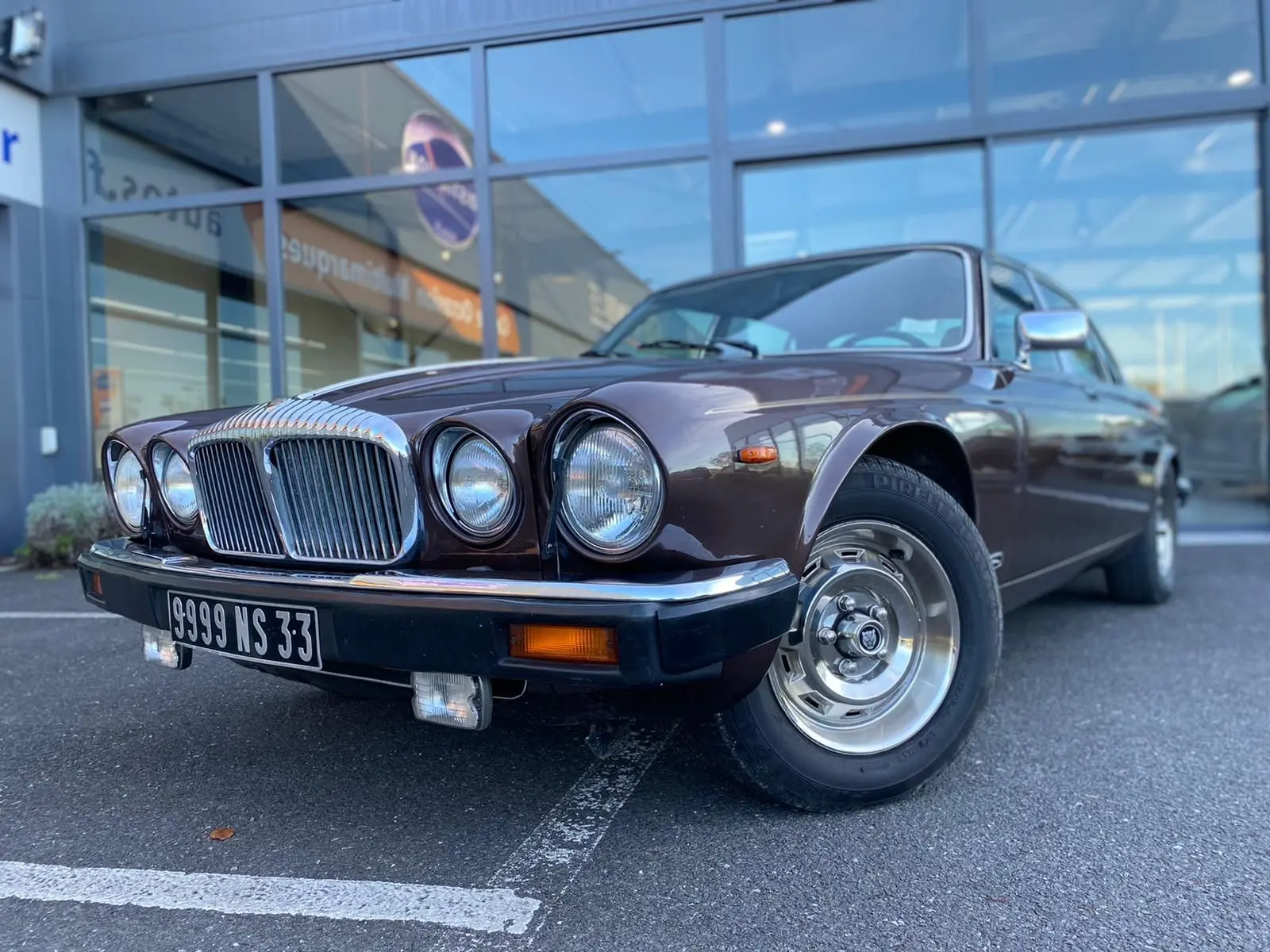 Jaguar XJ6 Série 3 4.2 Sovereign marron vue 3/4 avant droit, avec calandre chromée et phares ronds doubles.